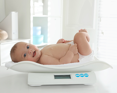 Baby auf einer Waage Baby auf einer Waage
